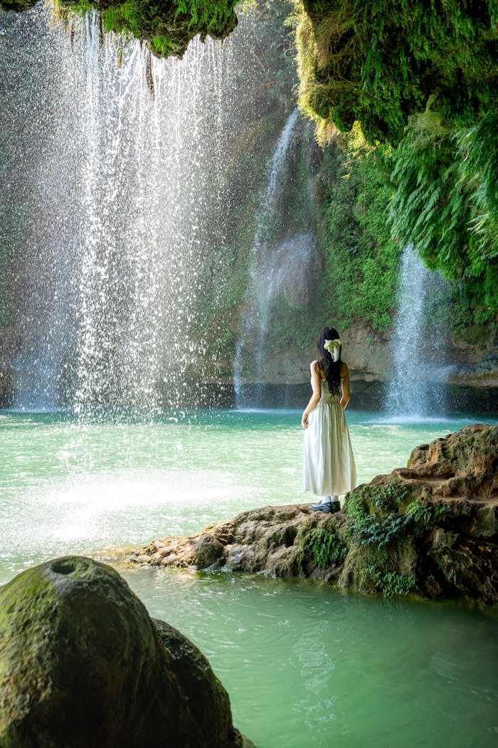 Serene scene of a woman admiring a waterfall in Sơn La, Vietnam.